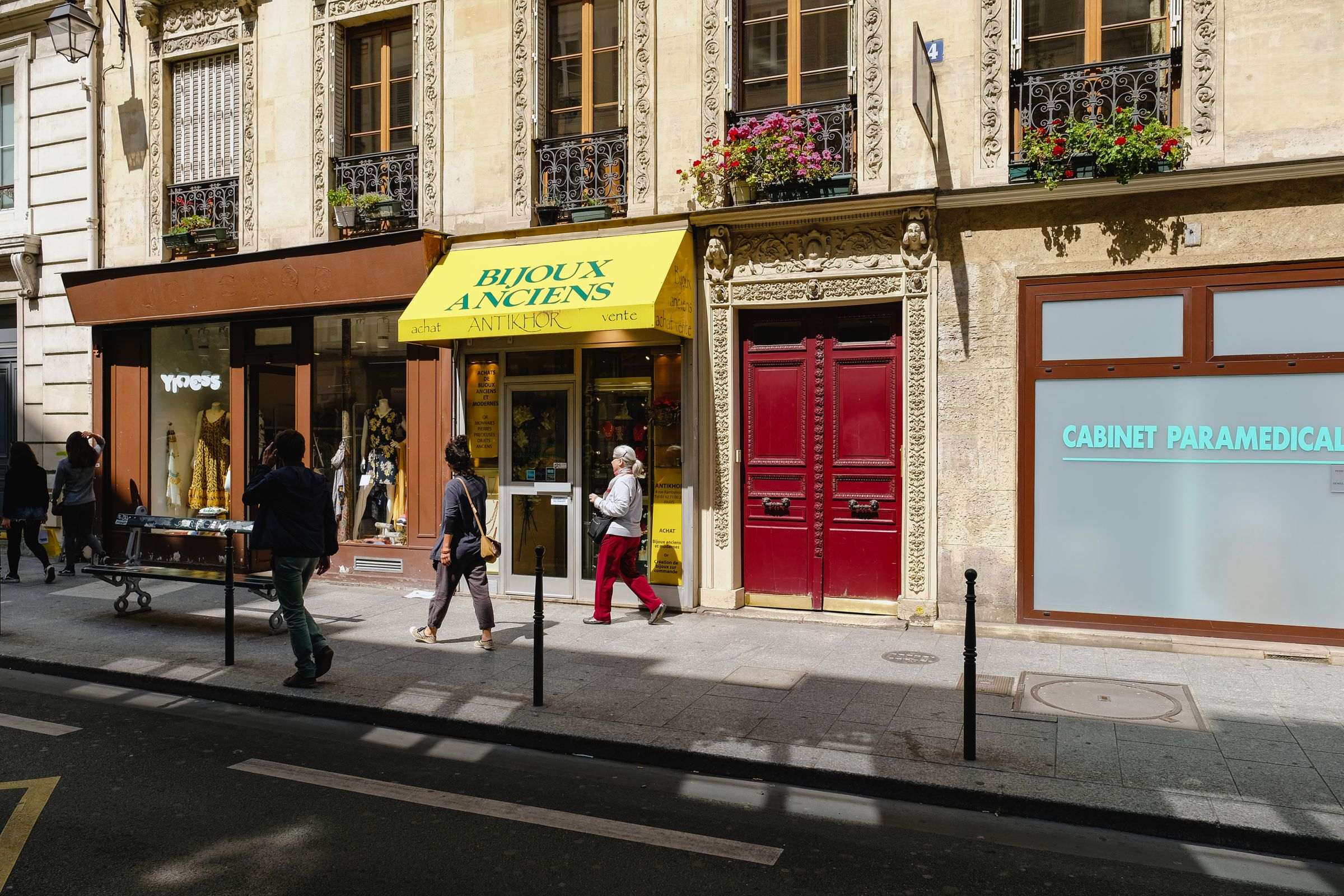 Rue de Paris bordée de boutiques et de cabinets au pied des immeubles